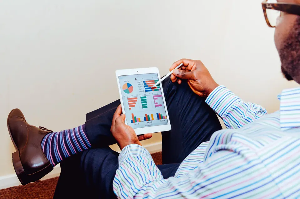 A person reviewing charts on a tablet.